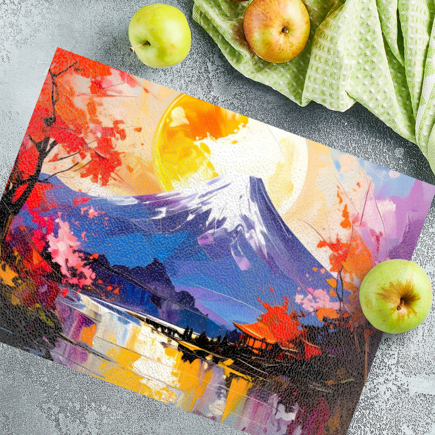 Colorful cutting board with a mountain and tree design on a gray surface with apples.