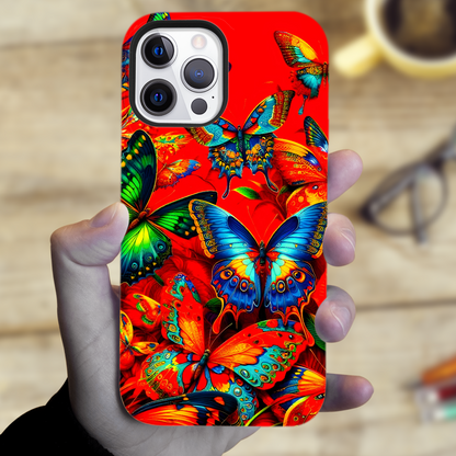 Phone case with colorful butterfly design held by a hand, blurred background
