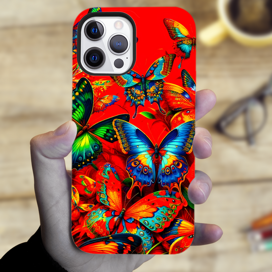 Phone case with colorful butterfly design held by a hand, blurred background